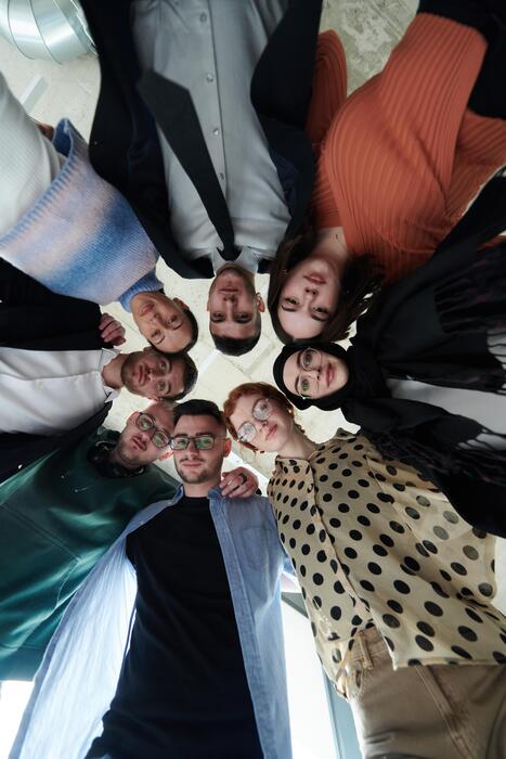 a diverse group of business professionals standing together in a powerful united pose captured from a low angle perspective exuding confidence and teamwork photo